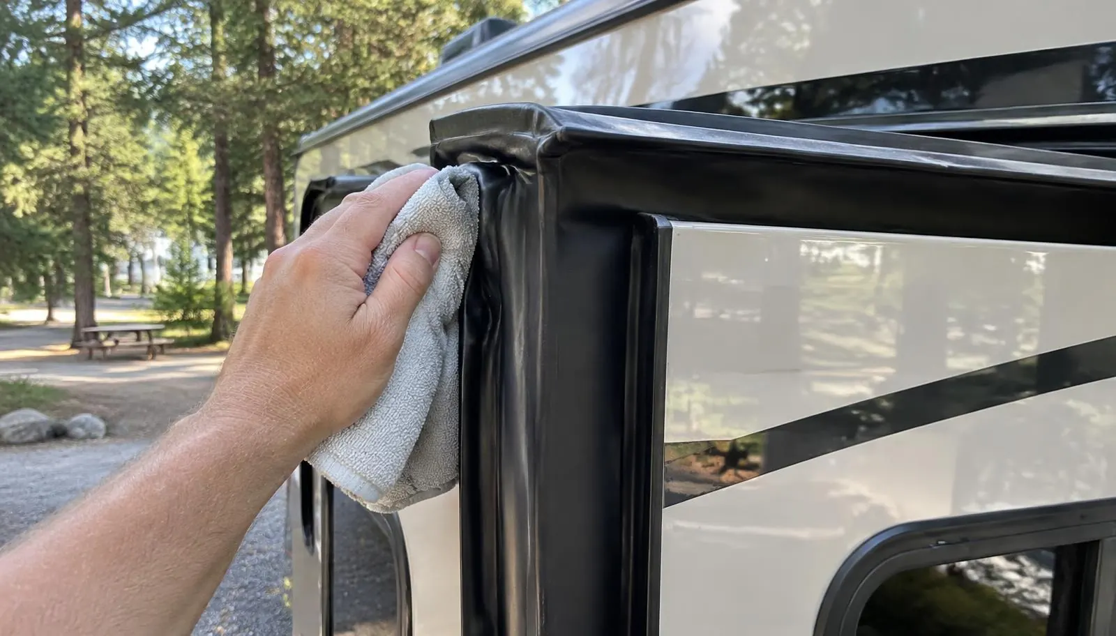 Owner wiping the rubber seal on the edge of an RV slide-out room